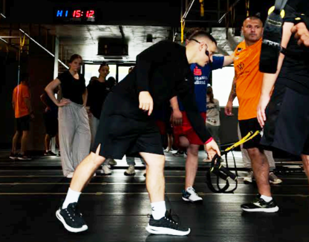 Тренер фітнес-студіїХ-Move Юрій Хомут проводить інструктаж з використання TRX-петель у вправах ампспортменів