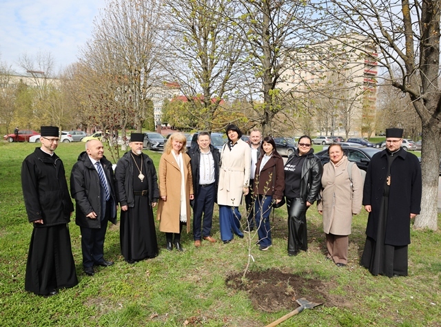  Працівники фізмату біля посадженого куща бузку